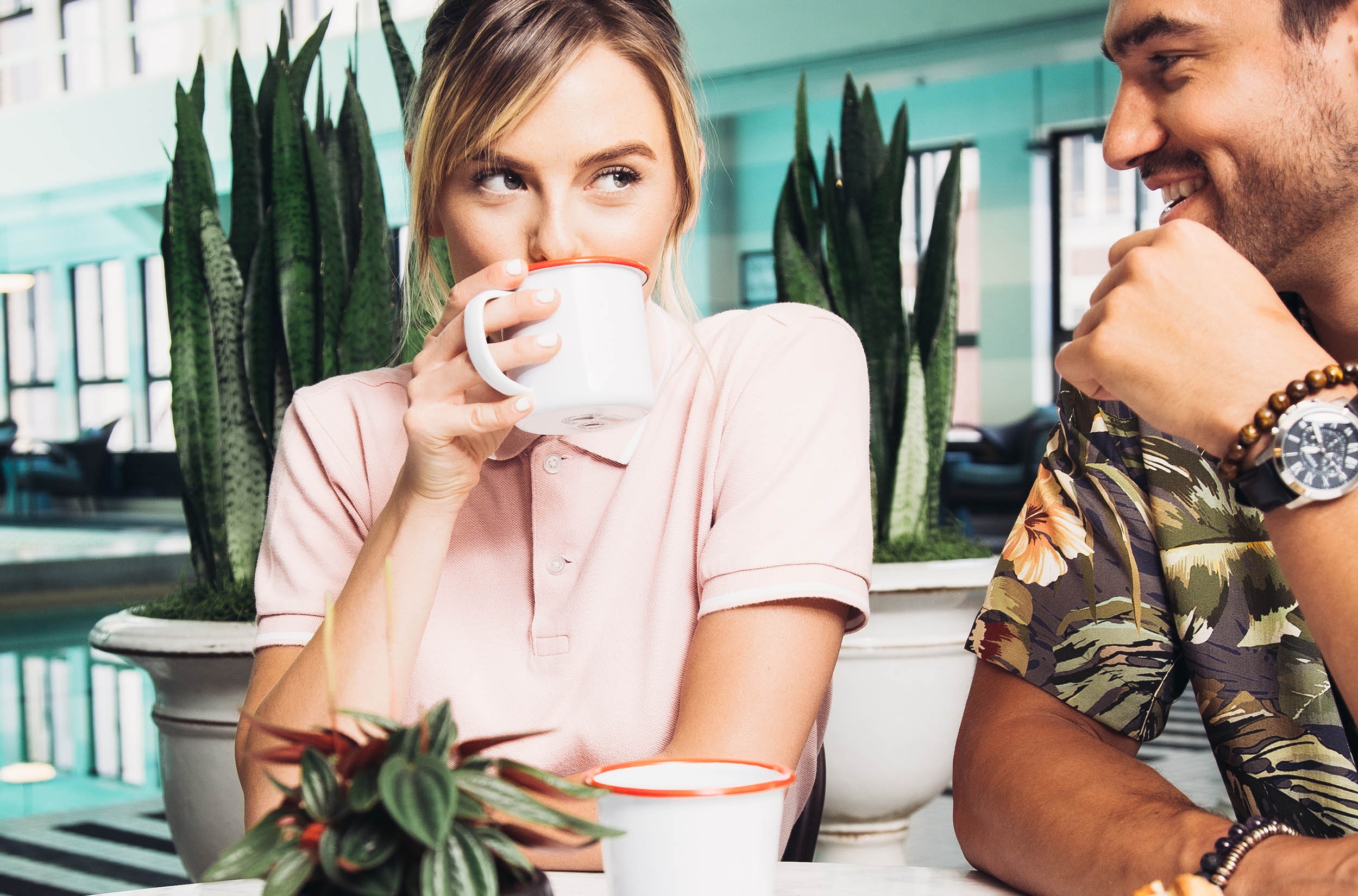 Breakfast Club Offer; Woman drinking coffee at coffee shop next to man