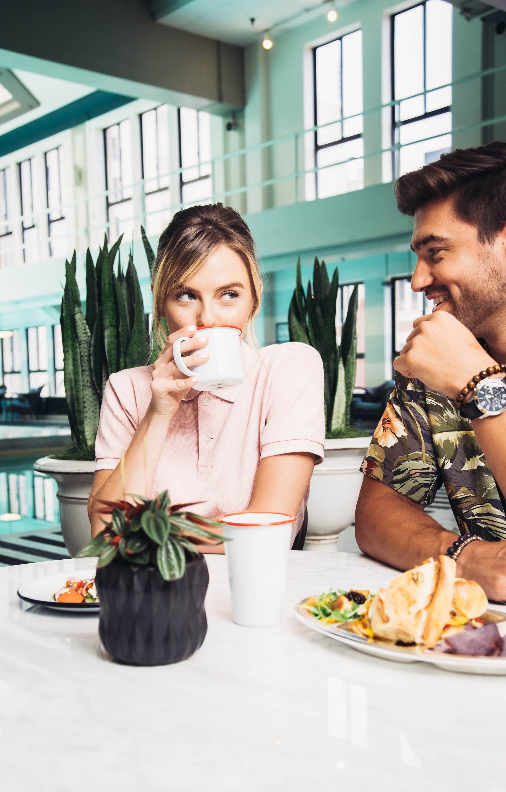 Breakfast Club Offer; Woman drinking coffee at coffee shop next to man