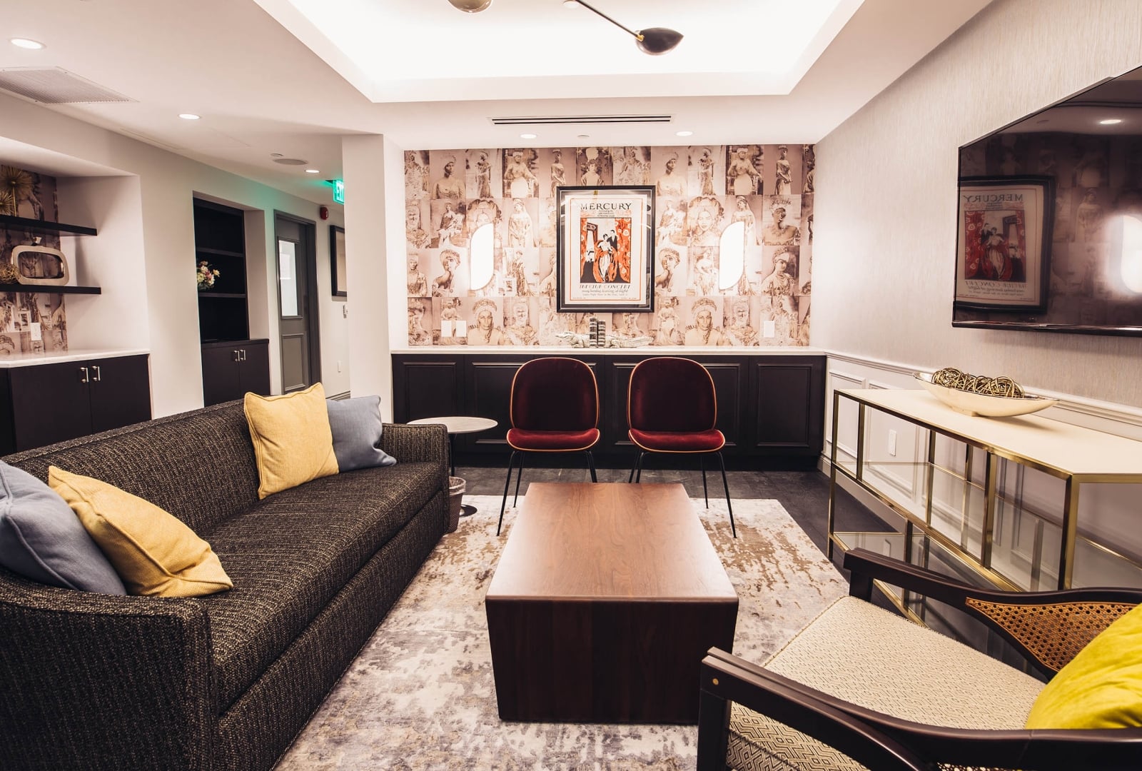 A hotel lobby lounge with a sofa, coffee table, chairs, and TV.