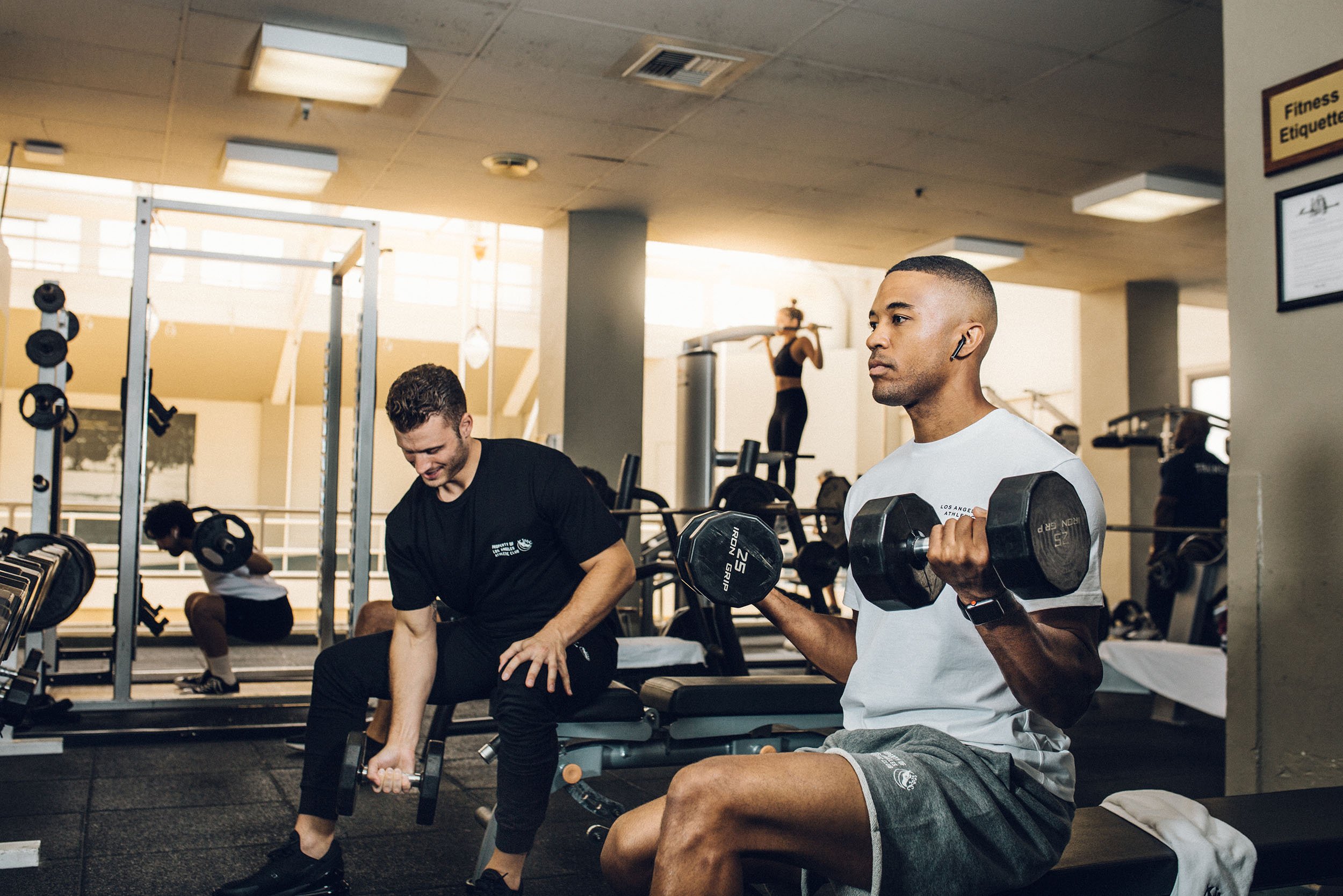 Los Angeles Athletic Club hotel indoor gym with guests lifting weights.