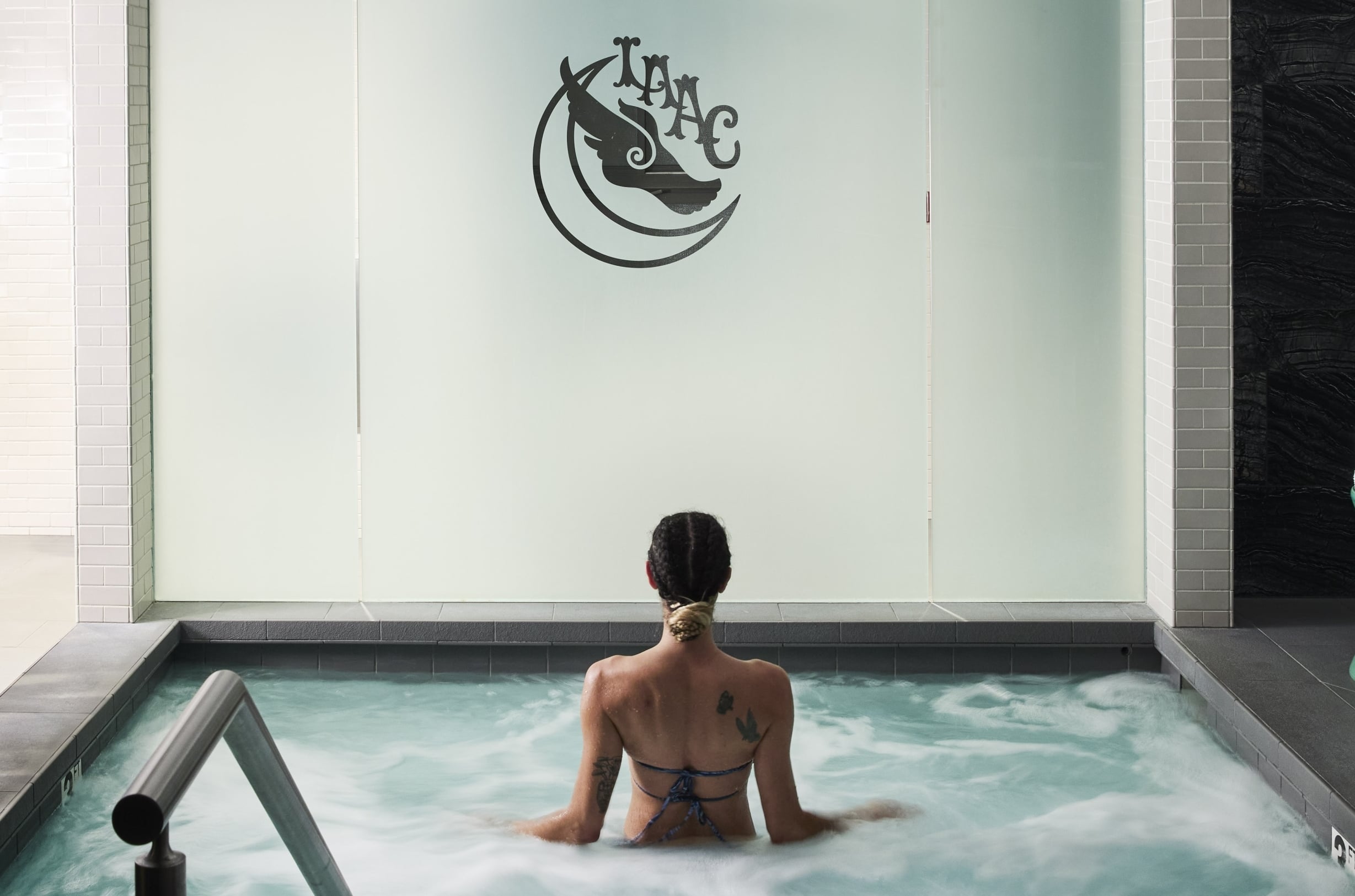 A woman submerges into a foamy jacuzzi pool at the LAAC