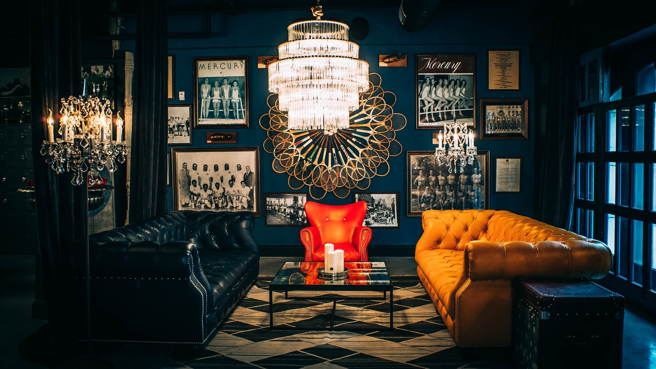 Los Angeles Athletic Club Blue Room; LA downtown bar with blue walls, hung vintage pictures, two leather couches and one center red chair.