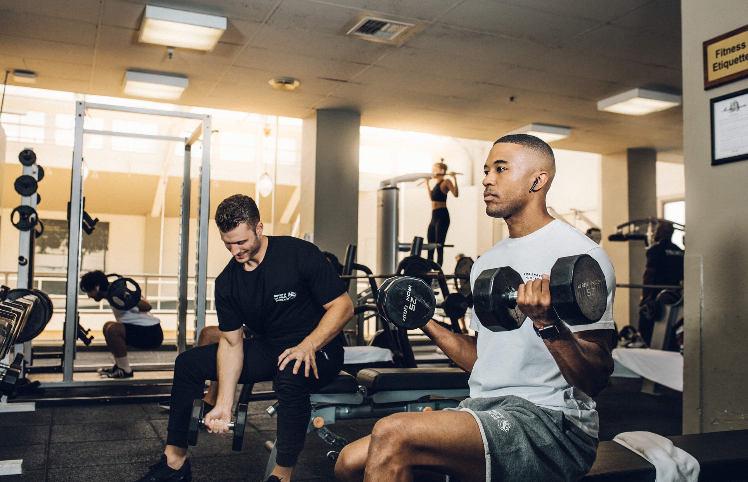 LA hotel indoor gym with guests lifting weights.