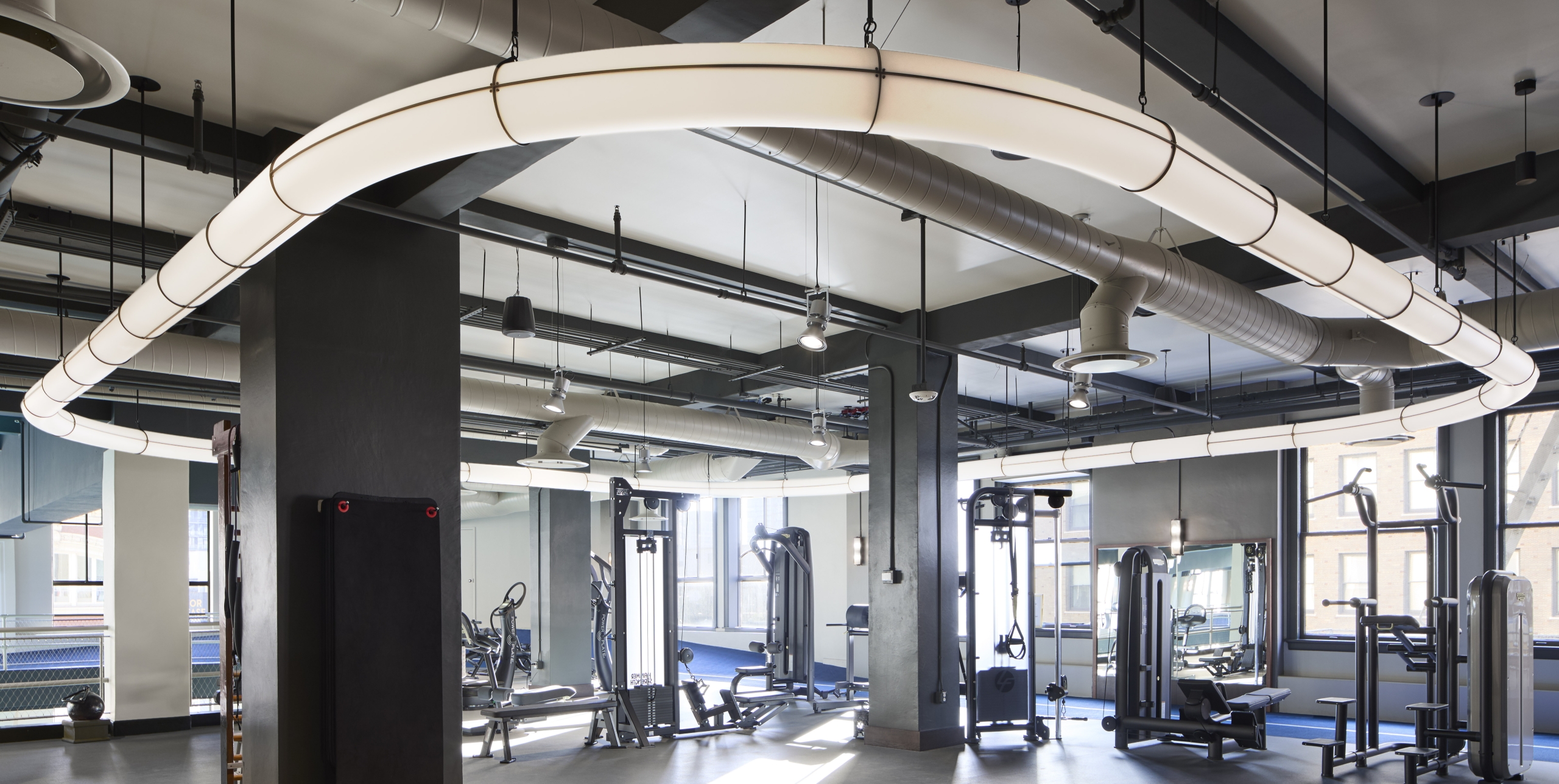 A well-equipped gym with modern exercise machines and ample lighting.