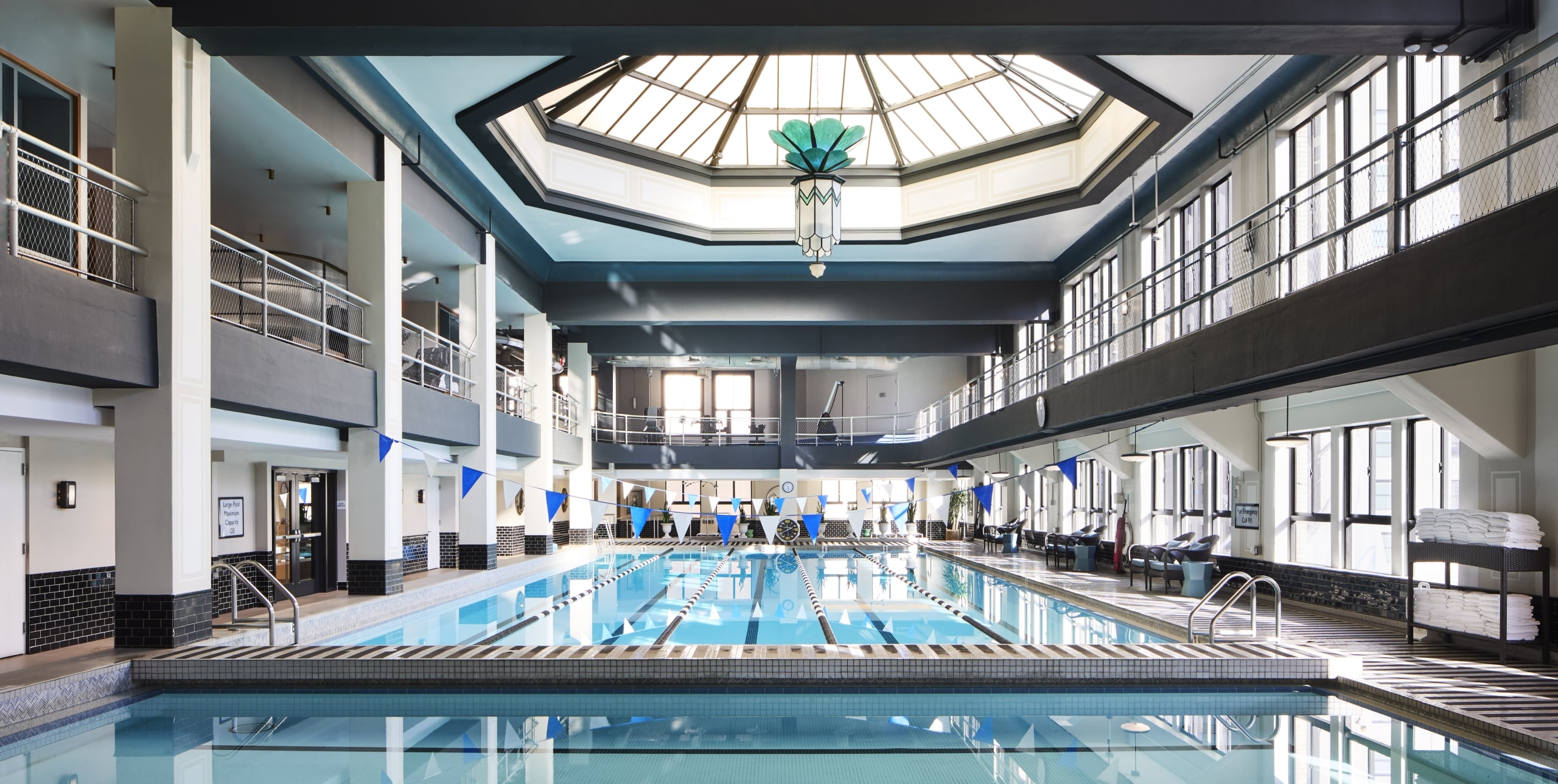 A large indoor pool with a balcony and skylight