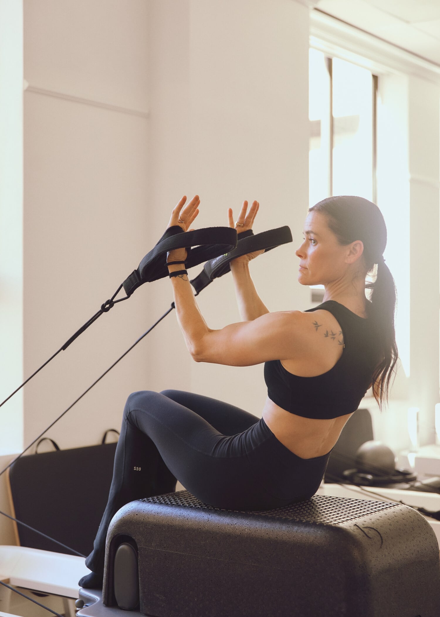 A woman exercising on a pilates reformer